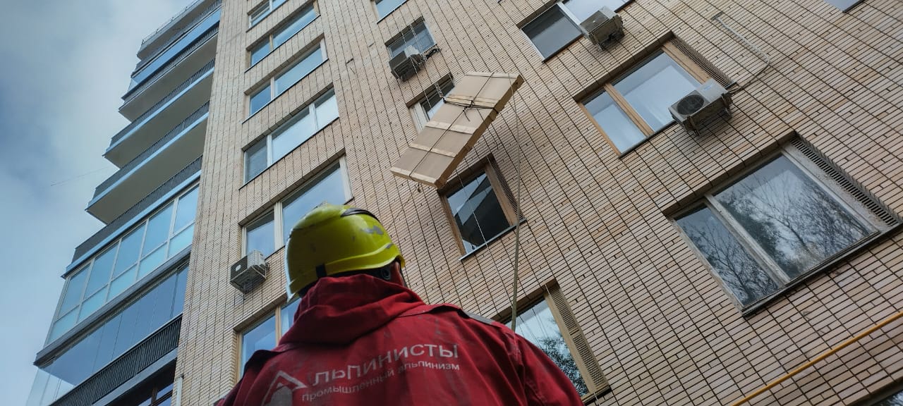 Промышленный альпинист оценивает фасад перед подъемом груза